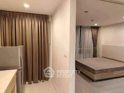Modern apartment interior with bedroom and kitchen area, featuring sleek design and neutral tones.