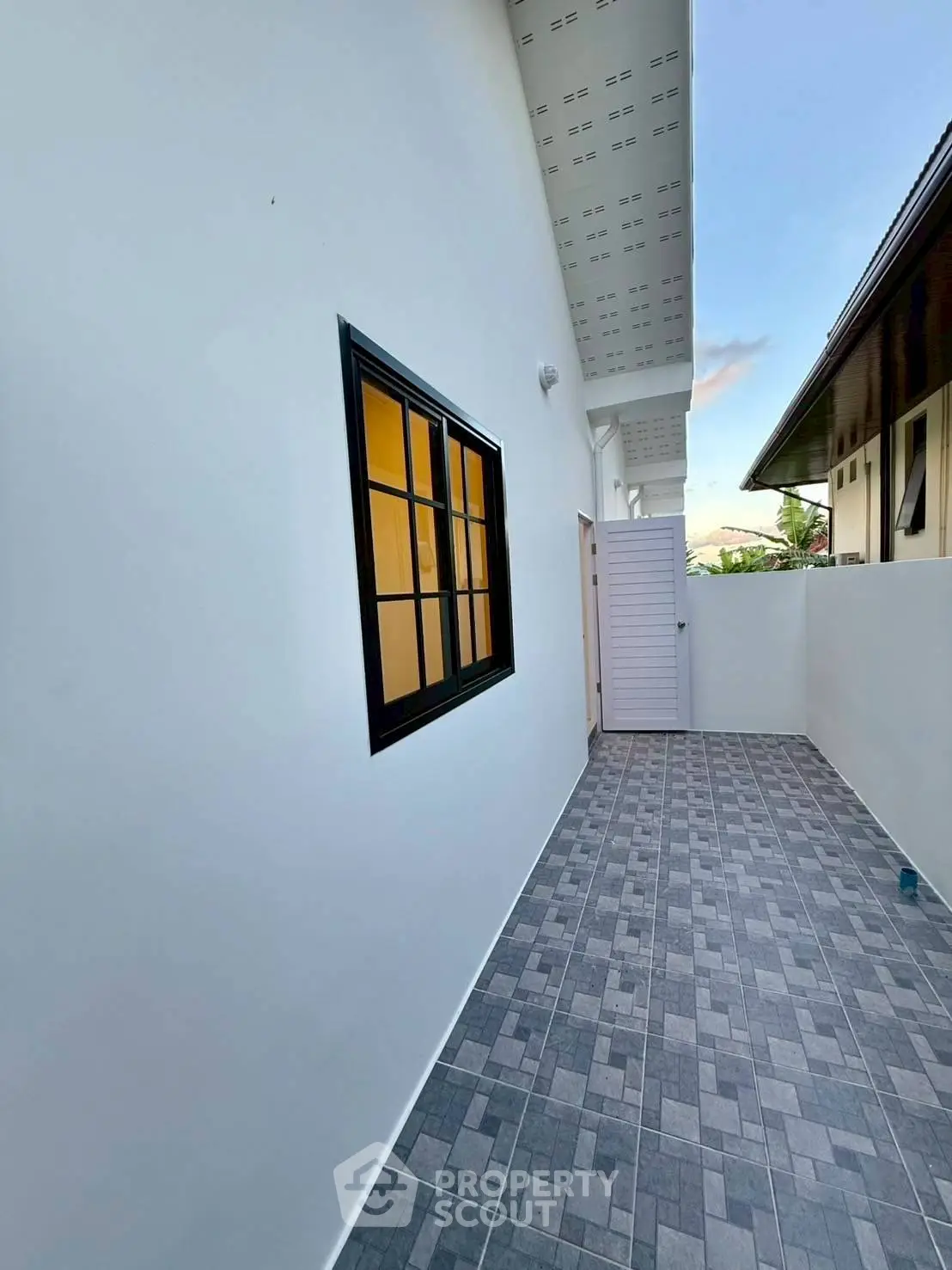 Modern exterior with sleek window and tiled pathway