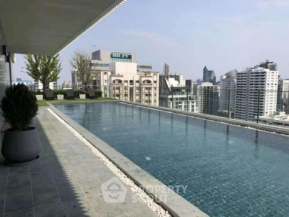Luxurious rooftop pool with stunning city skyline views in modern high-rise building.