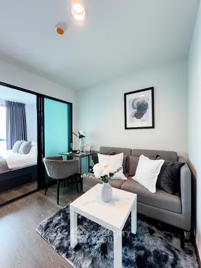 Modern living room with cozy decor and stylish furniture in a compact apartment setting.