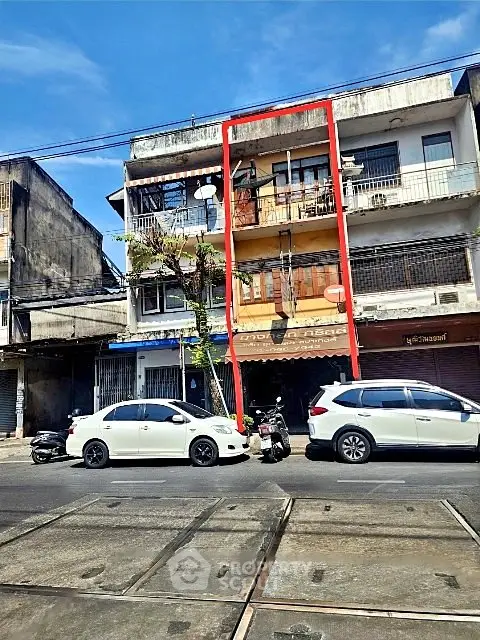 Charming urban building with potential, featuring a balcony and street view, ideal for investment or renovation.