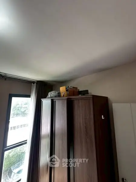 Cozy bedroom with large wardrobe and natural light from window