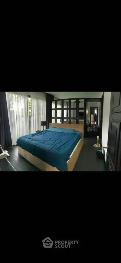 Luxurious bedroom with large windows and elegant decor, perfect for relaxation and comfort.