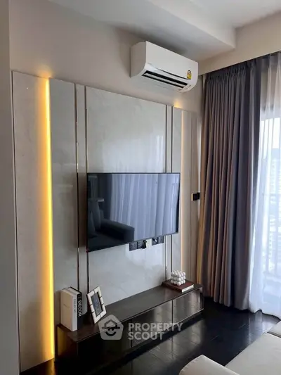 Modern living room with wall-mounted TV and air conditioning unit, featuring elegant decor.