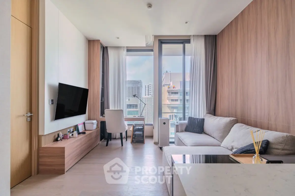 Modern living room with city view, featuring sleek furniture and large windows for natural light.