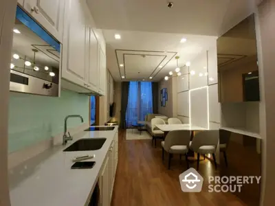 Modern open-layout kitchen and dining area with sleek design and wooden flooring.