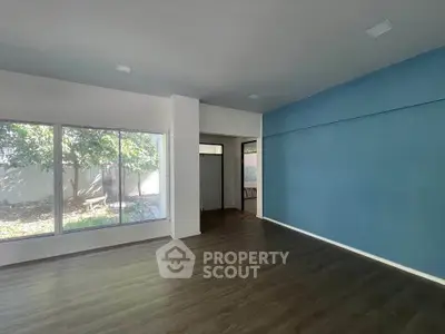 Spacious living room with large windows and blue accent wall