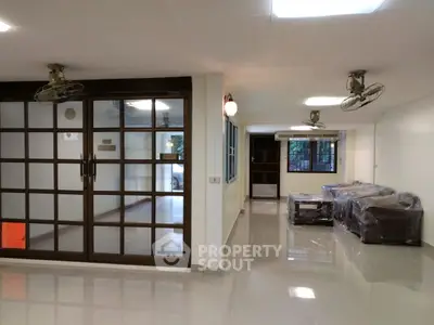 Spacious living room with glass doors and ceiling fans in modern home