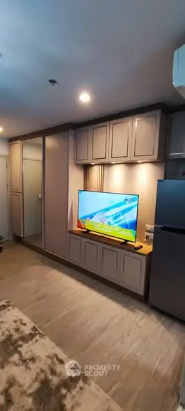 Modern living room with sleek cabinetry and flat-screen TV, featuring contemporary design and cozy ambiance.