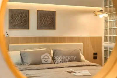 Modern bedroom with stylish decor and cozy lighting, featuring a comfortable bed and elegant wall art.