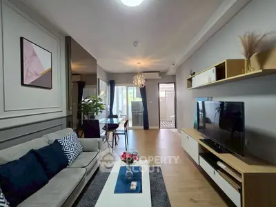 Modern living room with stylish decor and open layout, featuring a cozy sofa and large TV unit.