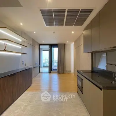 Modern open-layout kitchen with sleek cabinetry and city view from balcony.
