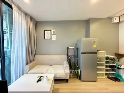 Cozy living room with modern decor and sleek refrigerator, perfect for urban living.