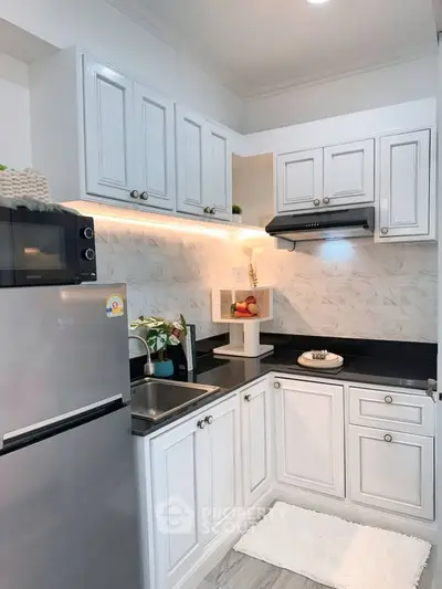 Charming modern kitchen with sleek white cabinetry and stainless steel appliances.
