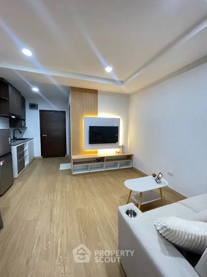 Modern living room with stylish TV setup and open kitchen layout