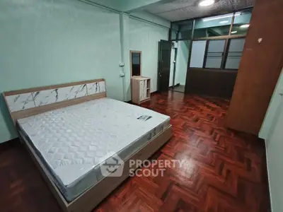 Spacious bedroom with wooden flooring and modern bed frame