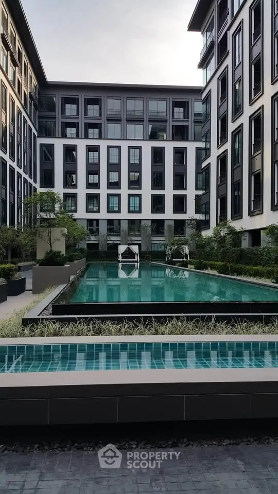 Modern apartment complex with a luxurious swimming pool and stylish architecture.
