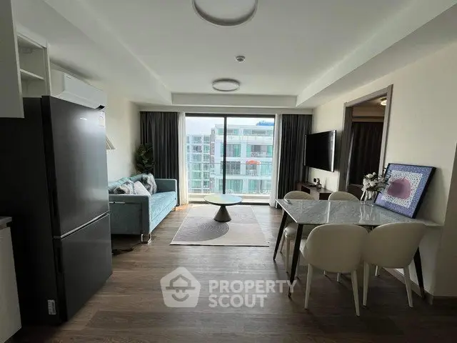 Modern living room with open layout, stylish furniture, and large windows offering city views.