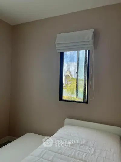 Cozy bedroom with a single bed and window view, perfect for a peaceful retreat.