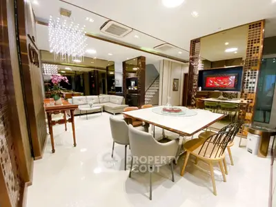 Luxurious open-plan living and dining area with modern decor and elegant lighting.