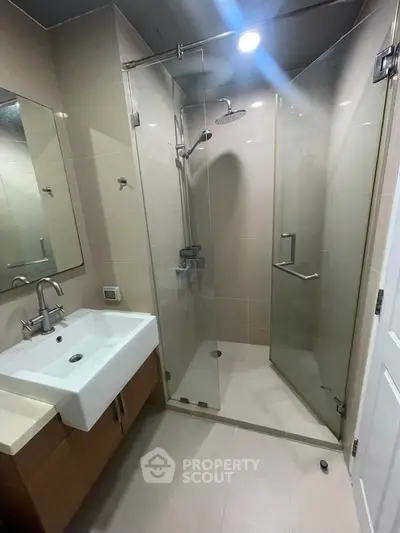Modern bathroom with glass shower enclosure and sleek fixtures