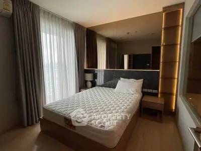 Modern bedroom with large window and stylish decor in a contemporary apartment.