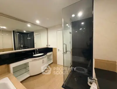 Luxurious modern bathroom with glass shower and elegant vanity in upscale property.
