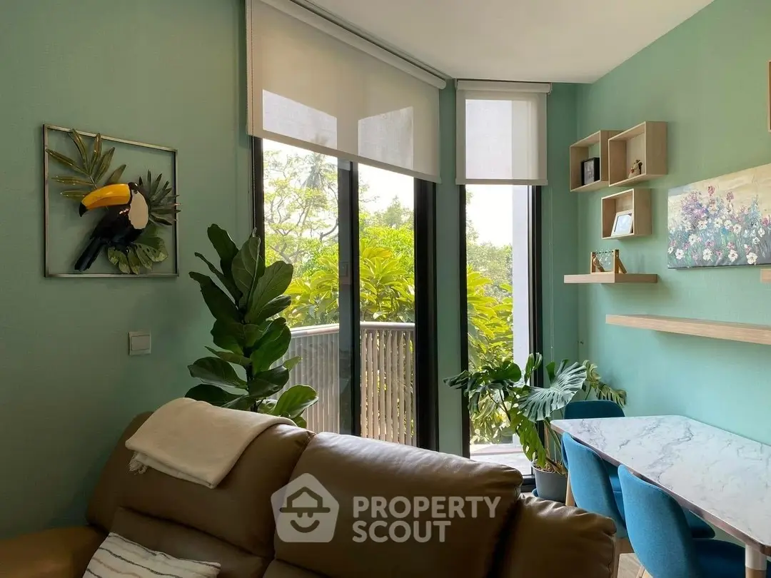 Charming living room with balcony view, modern decor, and lush greenery.