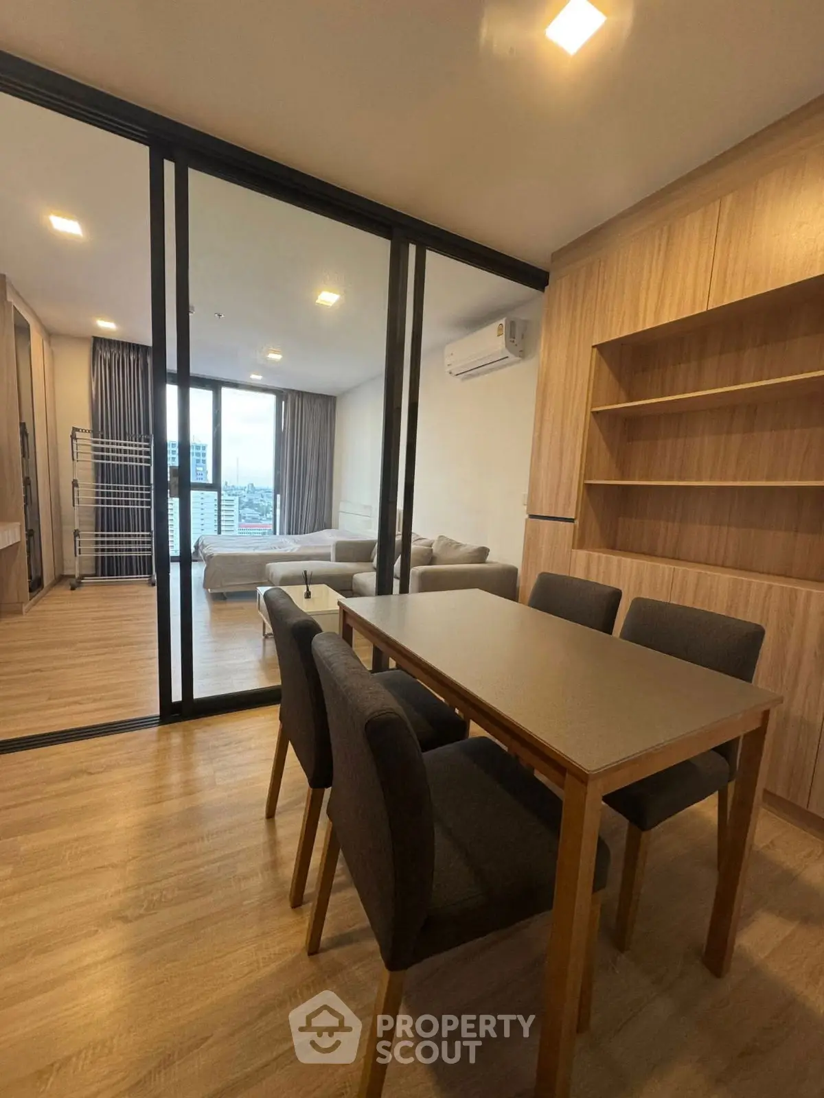 Modern dining area with wooden furniture and city view in a stylish apartment.