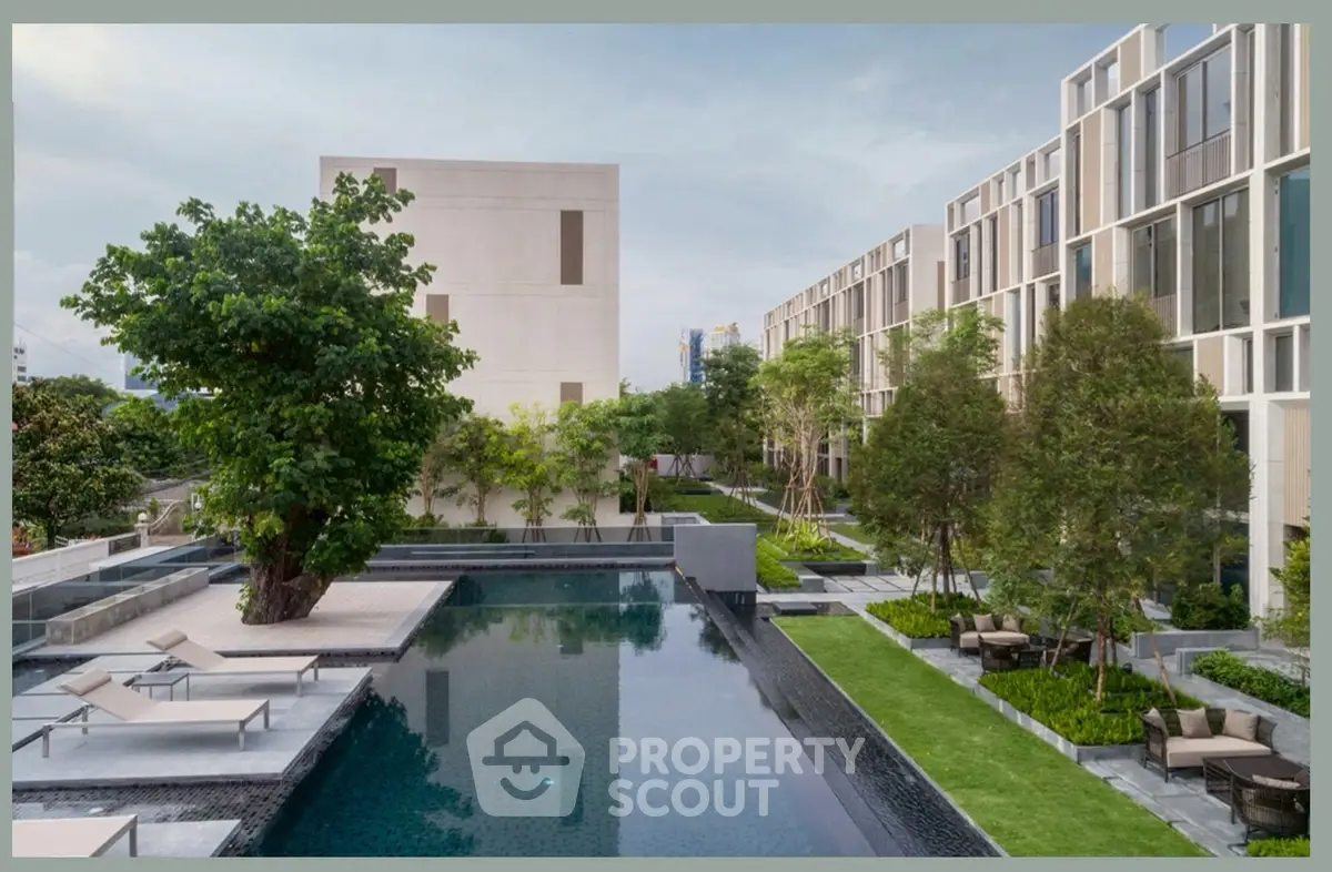 Luxurious modern apartment complex with stunning pool and lush garden landscaping.