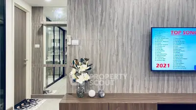 Modern living room with stylish decor and wall-mounted TV in contemporary apartment.