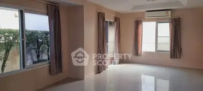 Spacious unfurnished living room with large windows and air conditioning, perfect for customization.