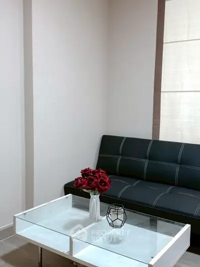 Modern living room with sleek black sofa and elegant glass coffee table