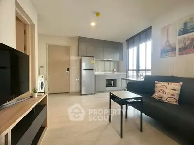 Modern open-layout living room with kitchen, featuring stylish decor and natural light.