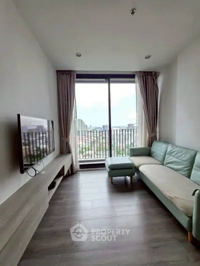Modern living room with large window and city view, featuring sleek furniture and elegant decor.