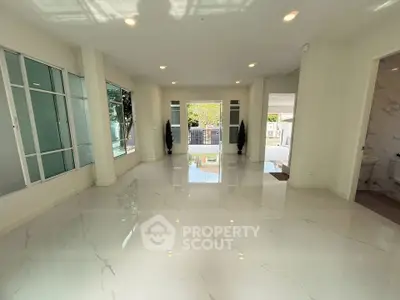 Spacious modern living room with glossy tile flooring and large windows