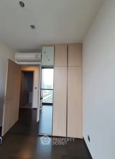 Modern bedroom with sleek wooden wardrobe and city view