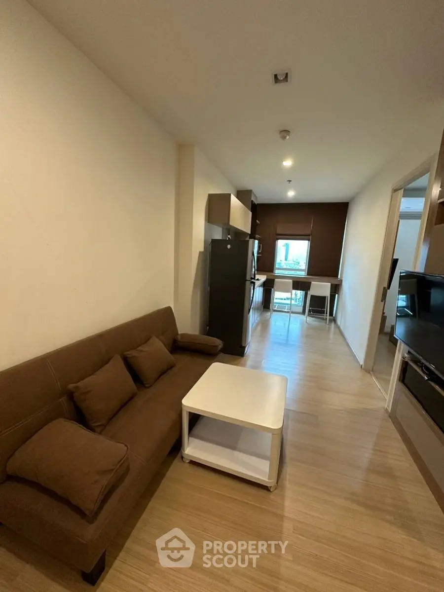 Modern living room with cozy sofa and stylish kitchen in open layout apartment.