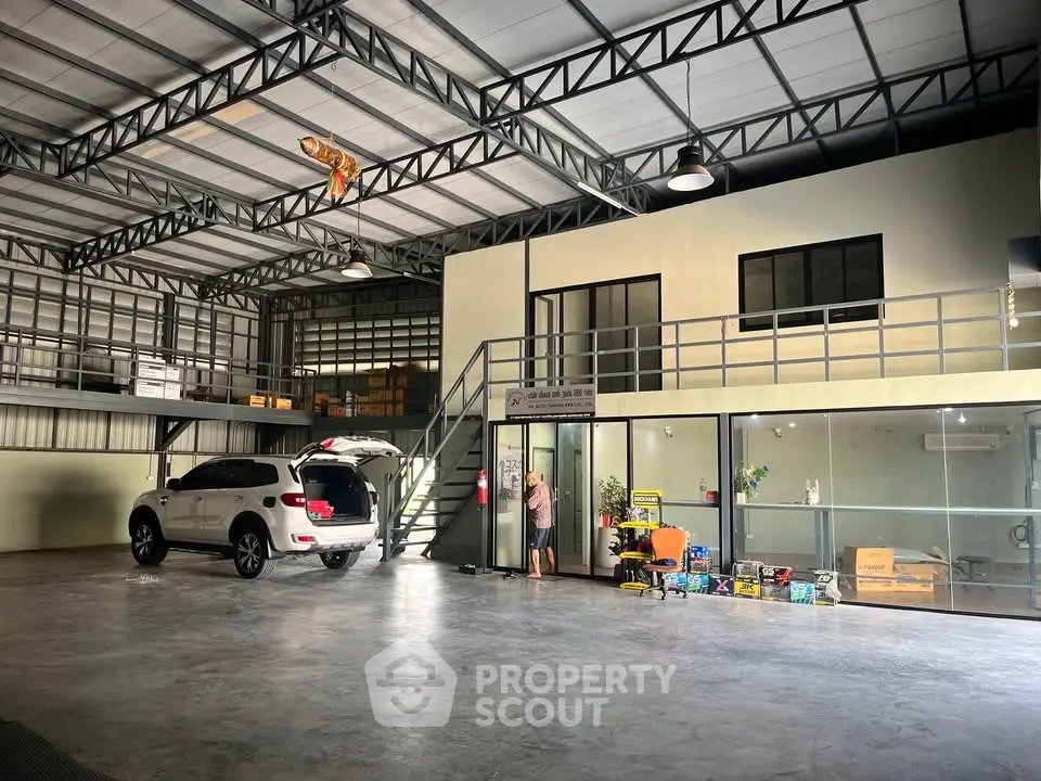 Spacious industrial warehouse with mezzanine office and ample parking space.