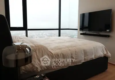 Luxurious bedroom with panoramic city view and modern wall-mounted TV.