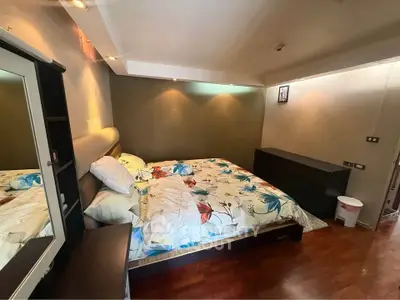Spacious bedroom with elegant lighting and hardwood floors