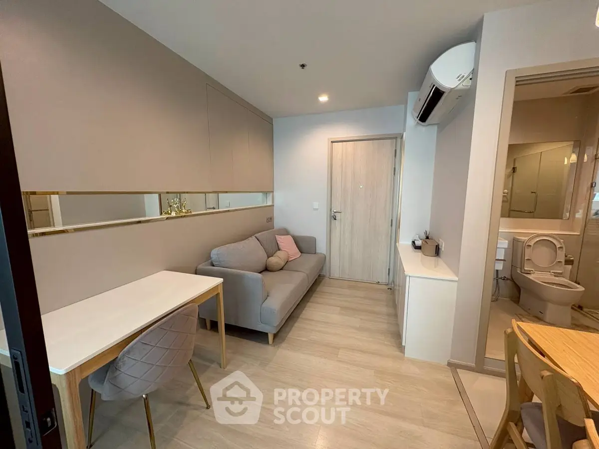 Modern living room with stylish decor and open layout, featuring a cozy sofa and dining area.