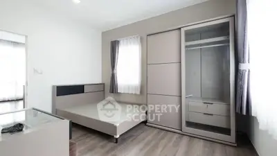 Modern minimalist bedroom with sleek furniture and ample natural light