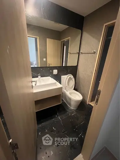 Modern bathroom with sleek black marble flooring and contemporary fixtures.