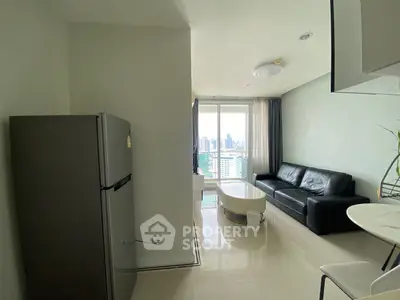 Modern living room with city view, sleek black sofa, and stainless steel fridge in open layout.