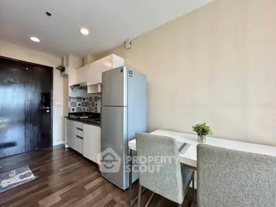 Modern kitchen with sleek appliances and dining area in a stylish apartment.