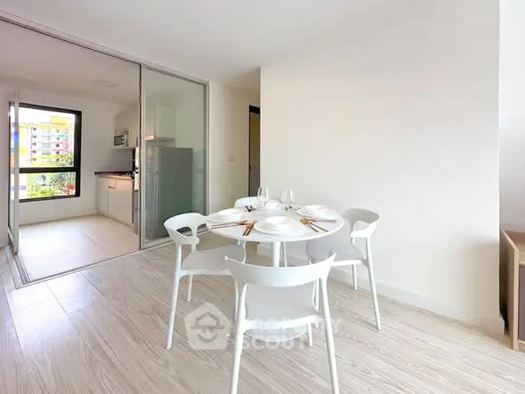 Modern dining area with white furniture and open kitchen layout