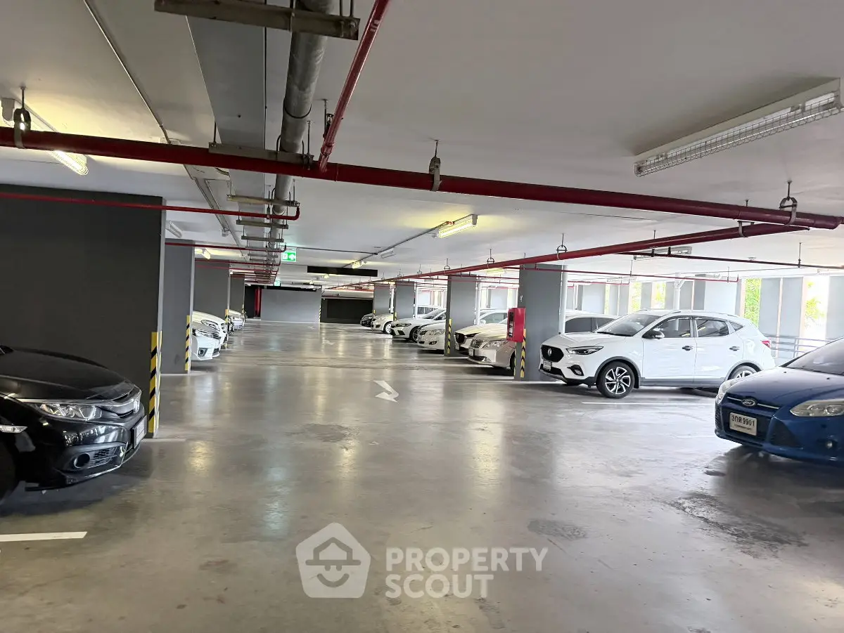 Spacious indoor parking area with multiple cars in a modern building.