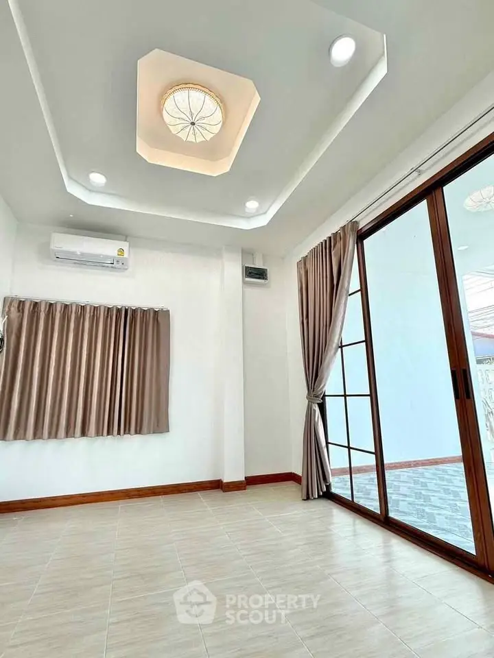 Spacious living room with modern ceiling design and large sliding glass doors.