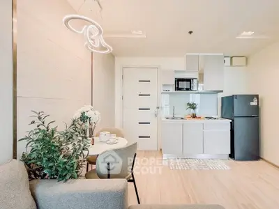 Modern open-plan kitchen and dining area with stylish lighting and sleek appliances.
